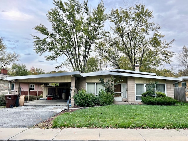 ranch-style home with a front yard and a carport