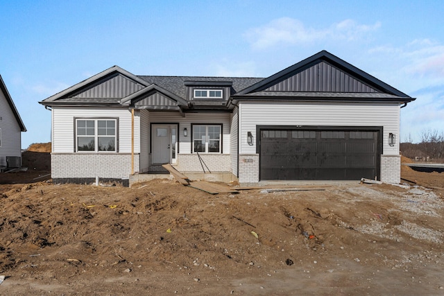 view of front facade featuring a garage, brick siding, central AC unit, and driveway