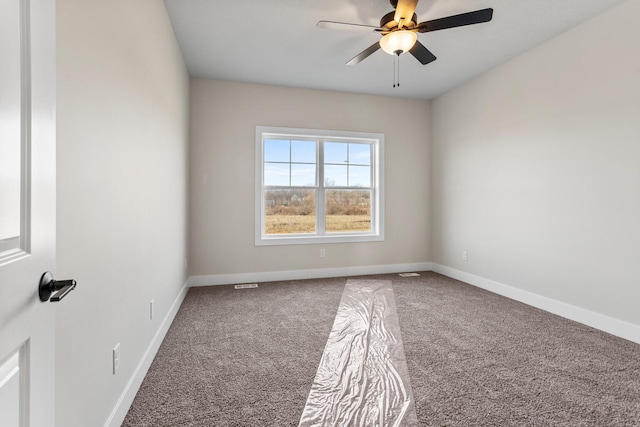 carpeted empty room featuring baseboards and ceiling fan