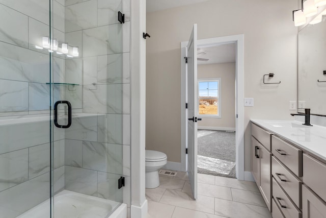 bathroom featuring visible vents, baseboards, toilet, a stall shower, and vanity