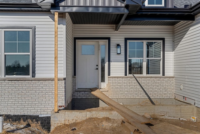 view of exterior entry with brick siding