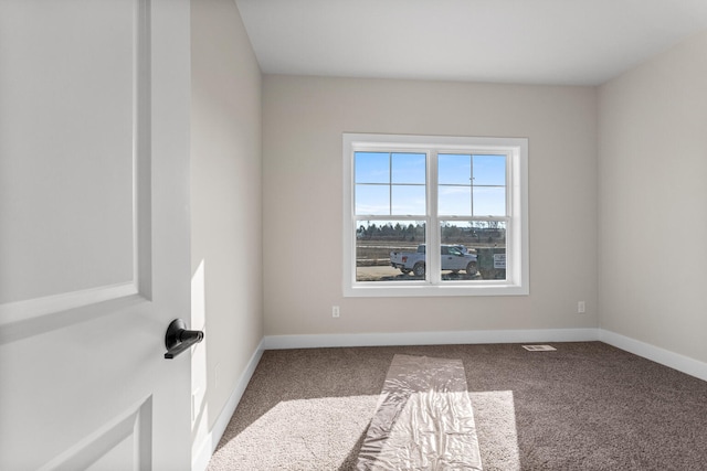 spare room with baseboards and carpet
