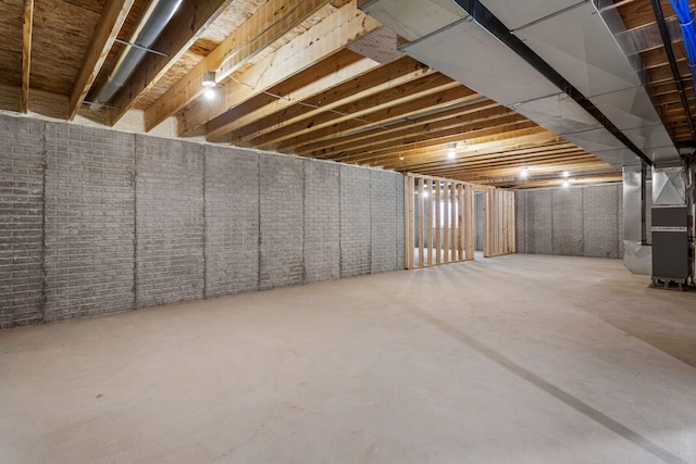 unfinished basement with heating unit and brick wall