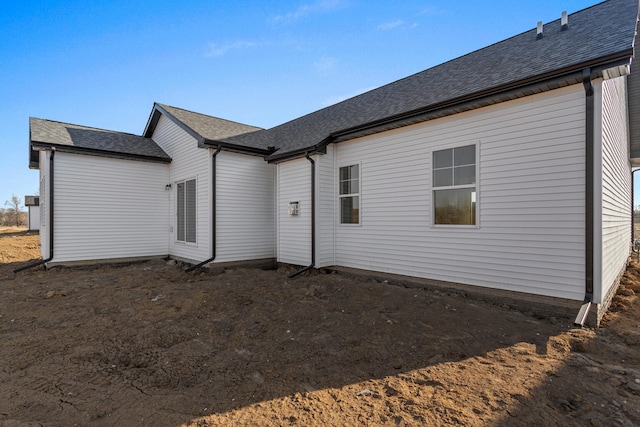 back of house with a shingled roof