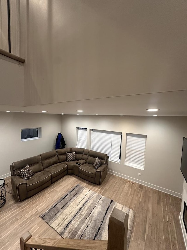 living room featuring light hardwood / wood-style flooring and a high ceiling