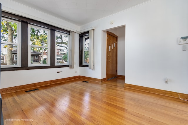 unfurnished room featuring light hardwood / wood-style floors and crown molding