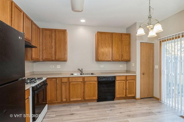 kitchen featuring light hardwood / wood-style flooring, a notable chandelier, black appliances, and sink