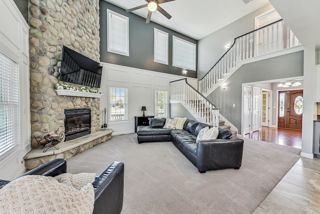 living room with a fireplace, a towering ceiling, and light hardwood / wood-style floors