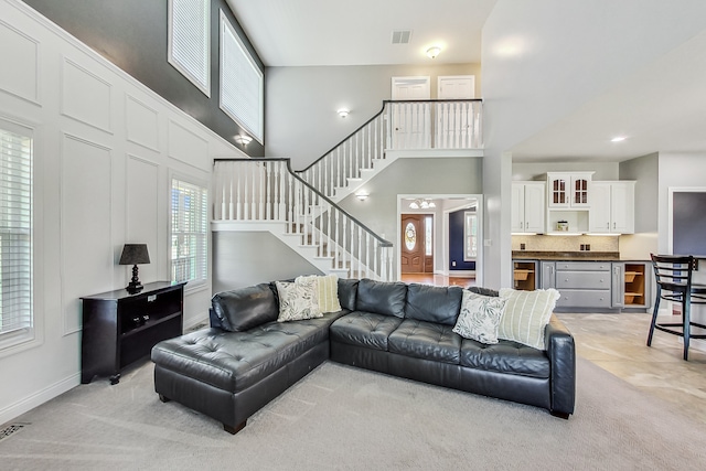 living room with a towering ceiling and wine cooler