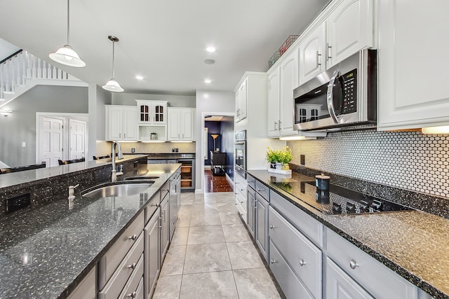 kitchen with pendant lighting, black appliances, and white cabinetry