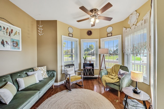 living area with dark wood-type flooring and ceiling fan