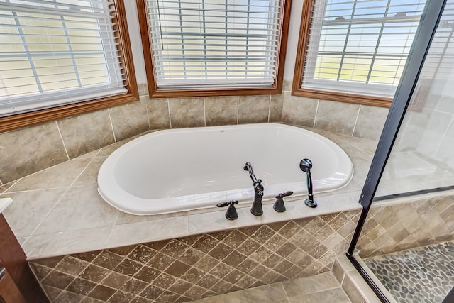 bathroom featuring independent shower and bath