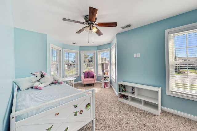 carpeted bedroom with multiple windows and ceiling fan