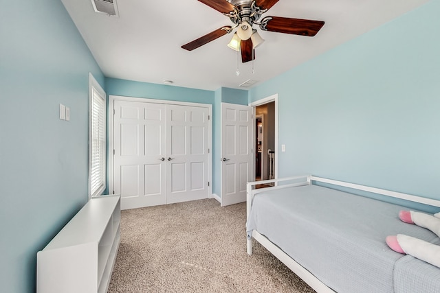 carpeted bedroom featuring ceiling fan and a closet