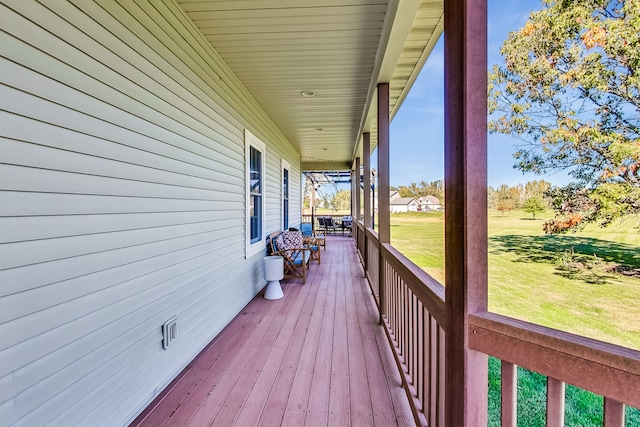 wooden terrace featuring a lawn