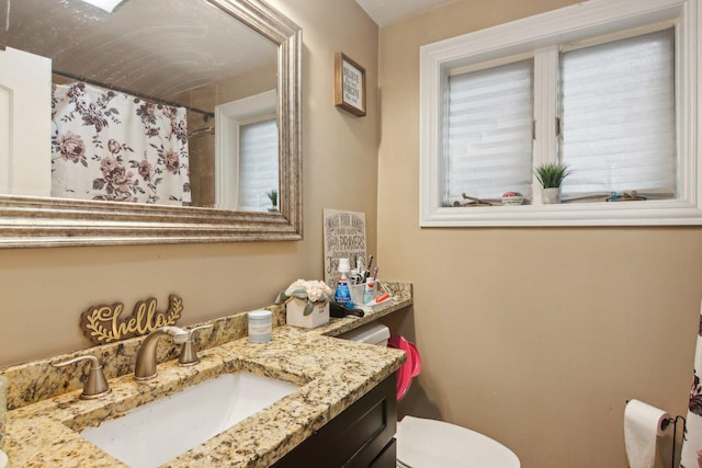 full bath with a shower with curtain, toilet, and vanity