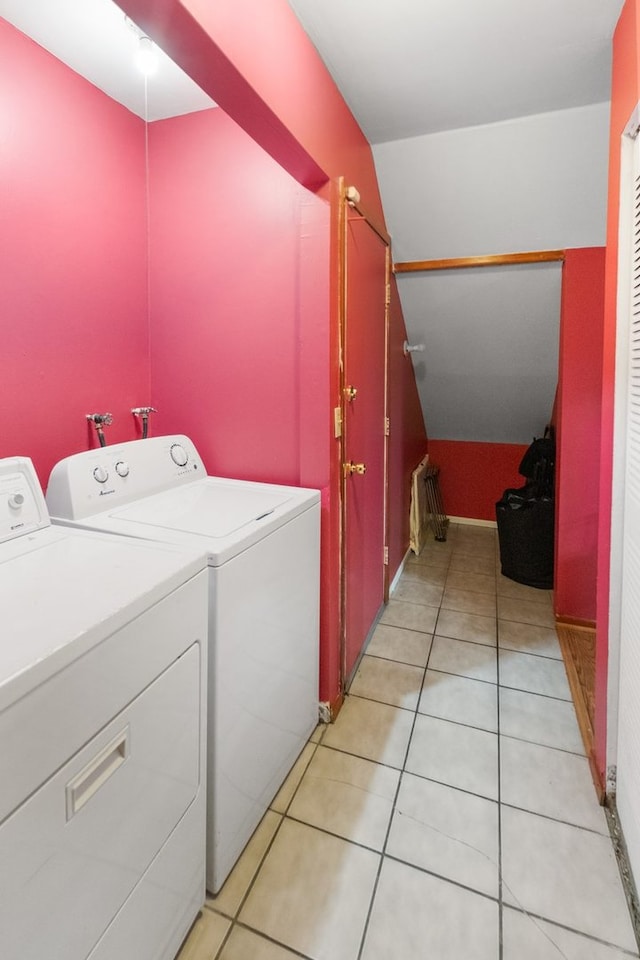 clothes washing area with washer and dryer and light tile patterned floors