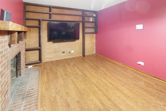 unfurnished living room with a fireplace and hardwood / wood-style floors