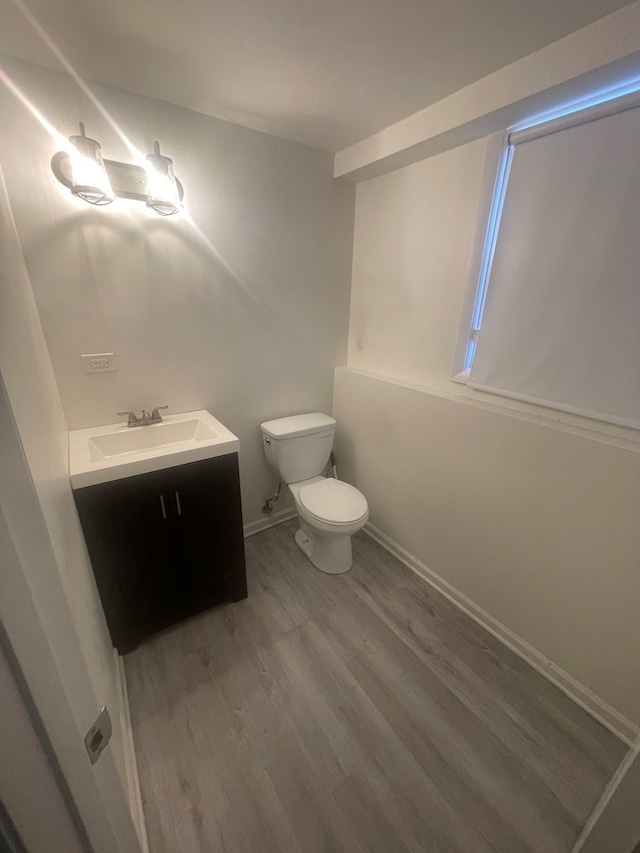 bathroom with wood-type flooring, vanity, and toilet