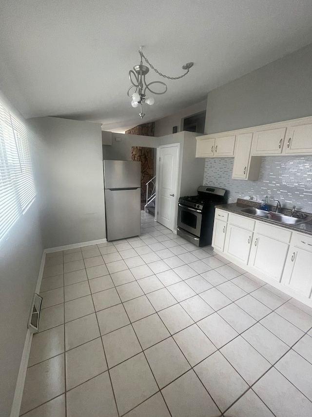 kitchen featuring an inviting chandelier, sink, decorative backsplash, appliances with stainless steel finishes, and white cabinetry