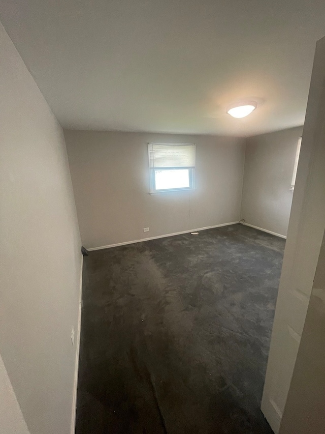 unfurnished room featuring dark colored carpet