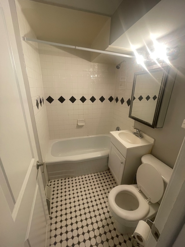 full bathroom featuring tile patterned floors, vanity, toilet, and tiled shower / bath