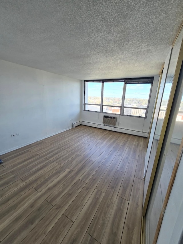 empty room with hardwood / wood-style floors and a textured ceiling