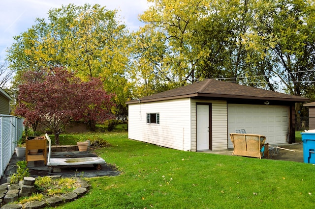 view of outdoor structure featuring a garage and a lawn