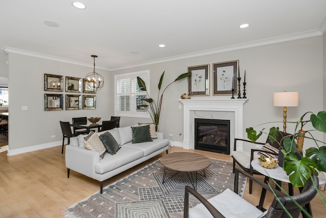 living room with a notable chandelier, crown molding, and light hardwood / wood-style floors