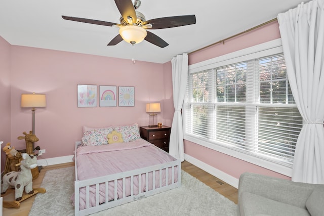 bedroom with light hardwood / wood-style flooring and ceiling fan