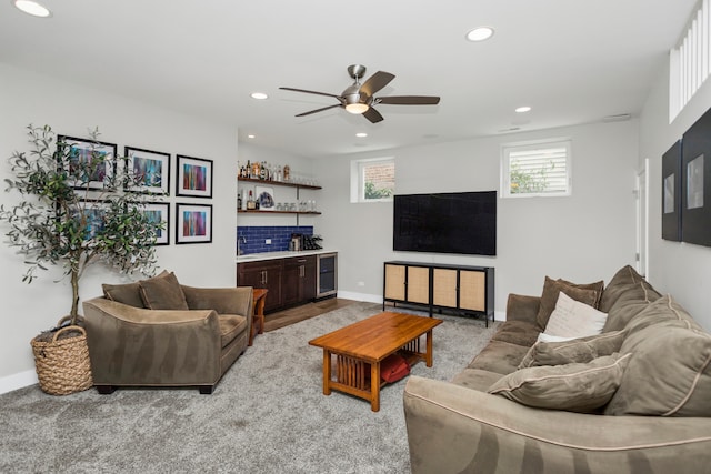 living room with bar, light colored carpet, and ceiling fan