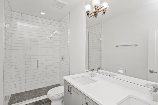 bathroom featuring a shower with shower door, vanity, and toilet