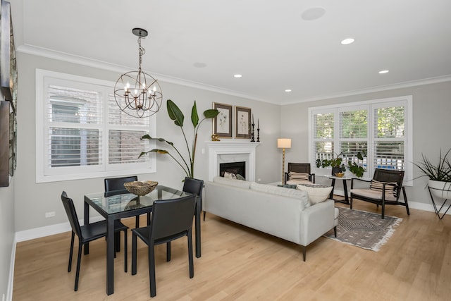 living room featuring ornamental molding, an inviting chandelier, and light hardwood / wood-style flooring