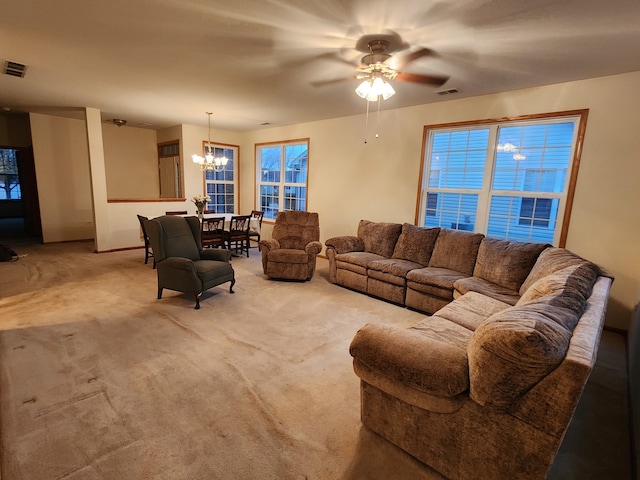 living room with a healthy amount of sunlight, ceiling fan with notable chandelier, and light carpet