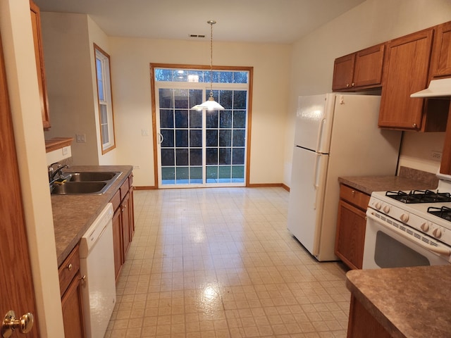 kitchen featuring white appliances, sink, and decorative light fixtures