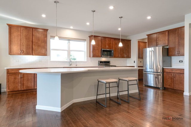 kitchen featuring dark hardwood / wood-style flooring, stainless steel appliances, and a kitchen island