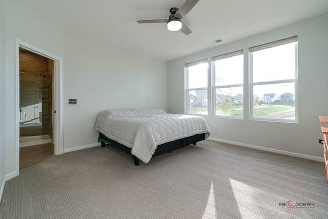 bedroom featuring connected bathroom, light colored carpet, and ceiling fan