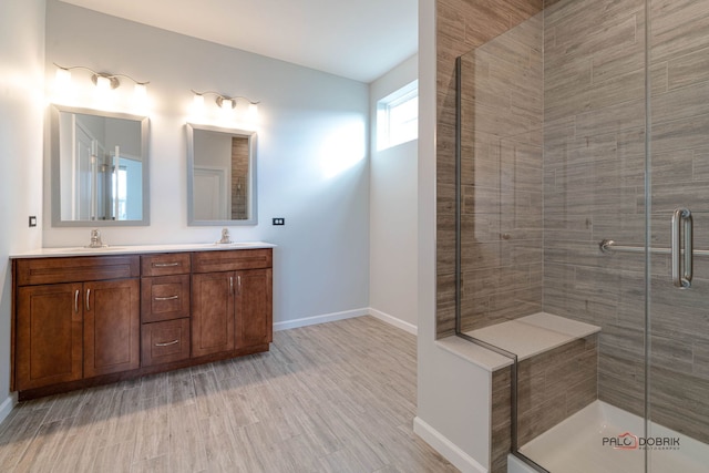 bathroom featuring vanity, wood-type flooring, and walk in shower