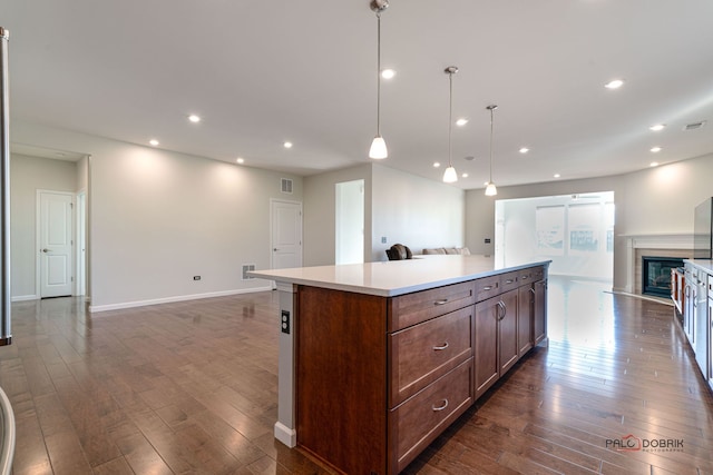 kitchen featuring dark wood-type flooring, pendant lighting, and a kitchen island