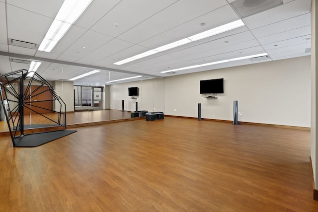 workout area featuring a paneled ceiling and wood-type flooring