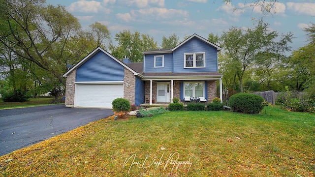 front of property featuring a garage, a front lawn, and covered porch