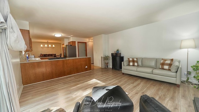 living room featuring a notable chandelier and light hardwood / wood-style floors