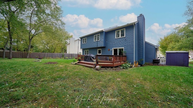 back of property with a shed, a yard, and a deck