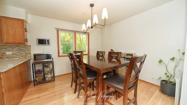 dining area featuring a notable chandelier and light hardwood / wood-style flooring