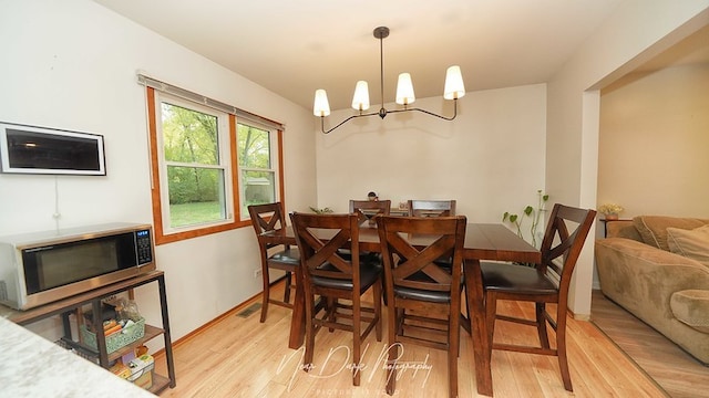 dining area with a chandelier and light hardwood / wood-style floors