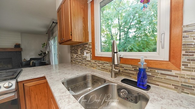 kitchen featuring light stone countertops, backsplash, and sink