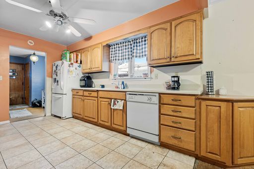 kitchen featuring ceiling fan, light tile patterned floors, and white appliances