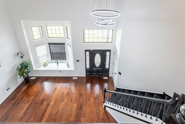 entryway with a high ceiling, dark hardwood / wood-style floors, and plenty of natural light