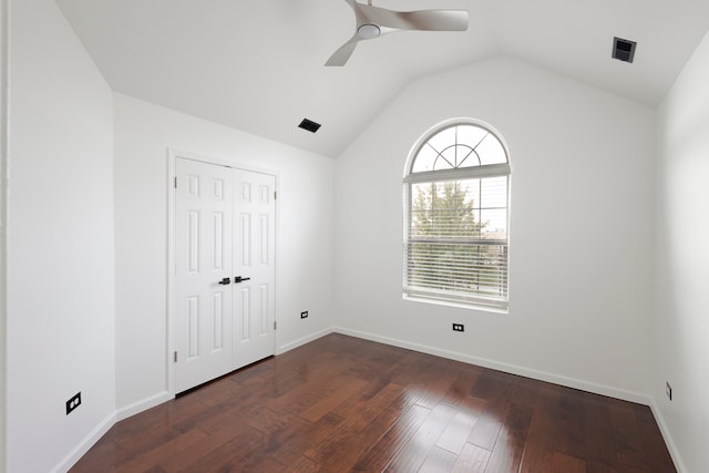 unfurnished bedroom with a closet, dark wood-type flooring, lofted ceiling, and ceiling fan