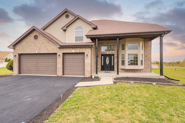 view of front facade with a yard and a garage